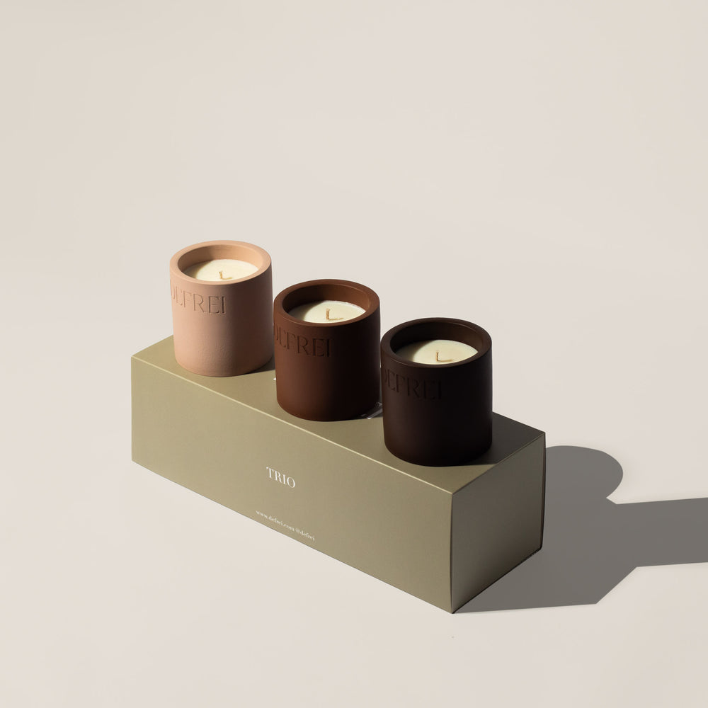 Sustainable packaging trio box of scented candles resting on a box showing LOBBY, AMOR and VANNILE