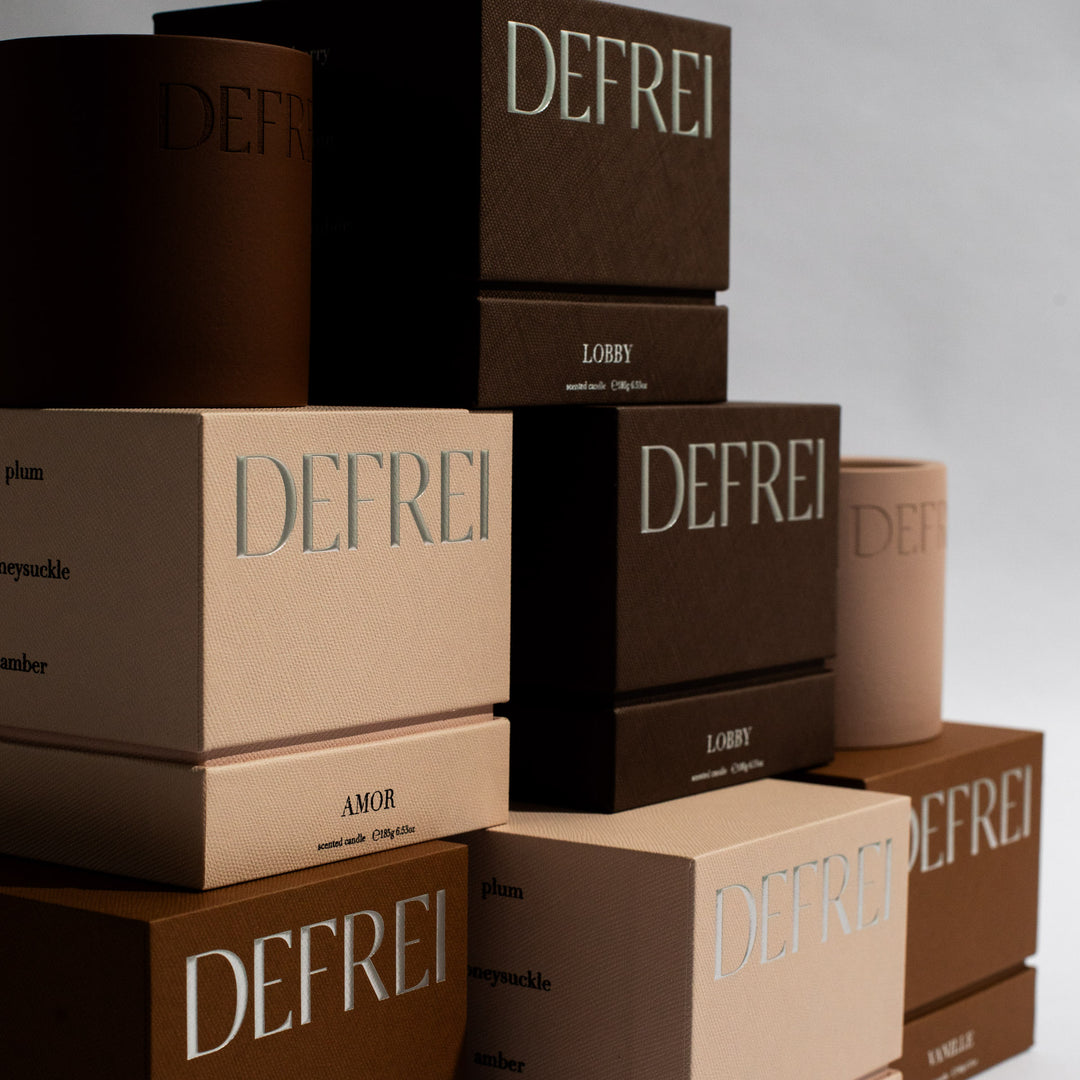 DEFREI stacked boxes, show the sustainable packaging of scented candles LOBBY, AMOR and VANNILE 